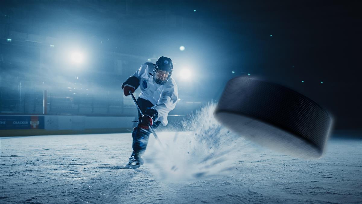 Bilde av en ishockeyspiller som skyter en puck - Klikk for stort bilde
